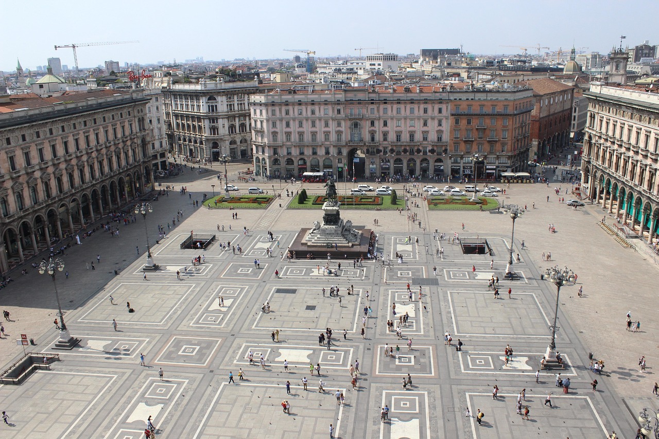 Piazza italiana affollata, visitatori ammirano monumenti e si godono l'atmosfera vivace.