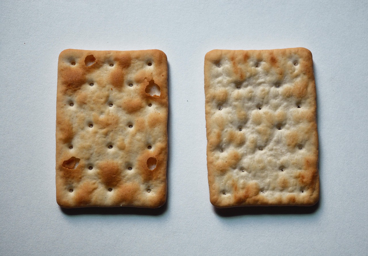 Immagine di diversi pacchetti di crackers, evidenziando le marche da evitare al supermercato.